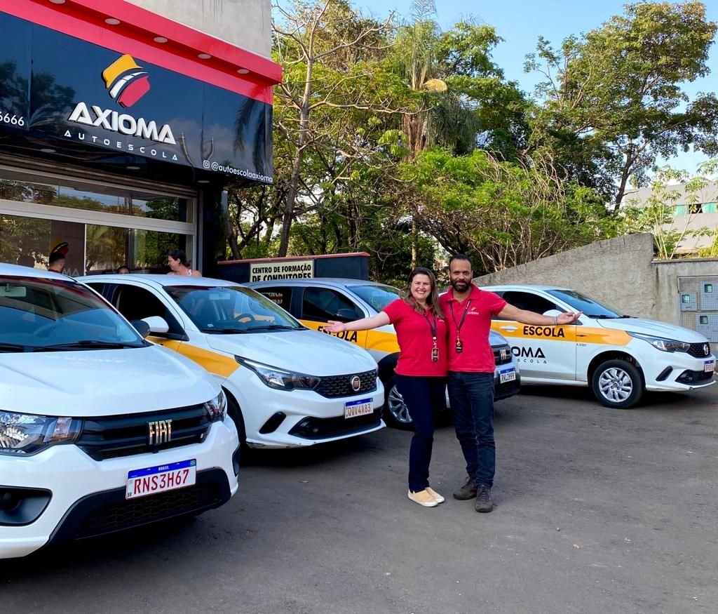Nadia Amorim e Emerson Nepumuceno, sócios da Axioma, em frente à autoescola e aos carros de aula em Sarzedo